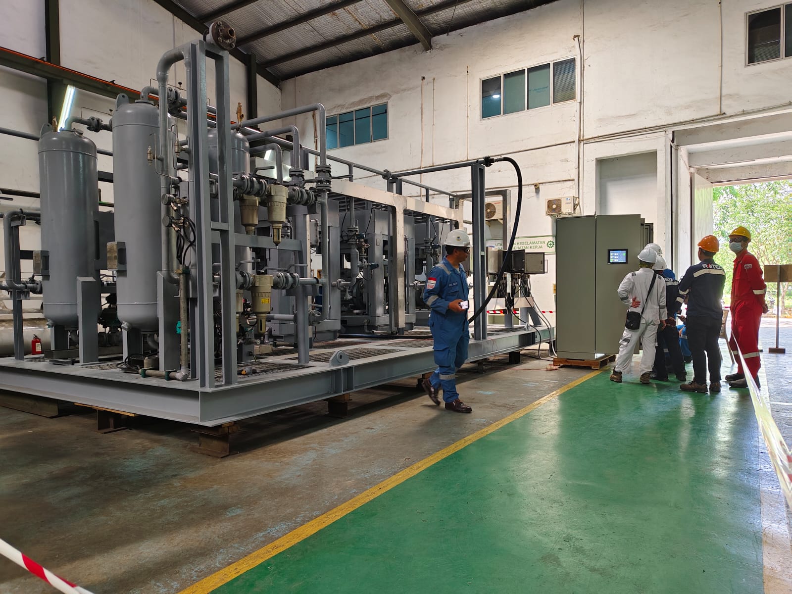 Workshop team beside a skid-mounted equipment package